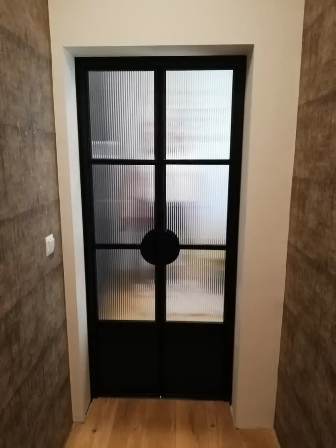 Black steel double doors with textured reeded glass